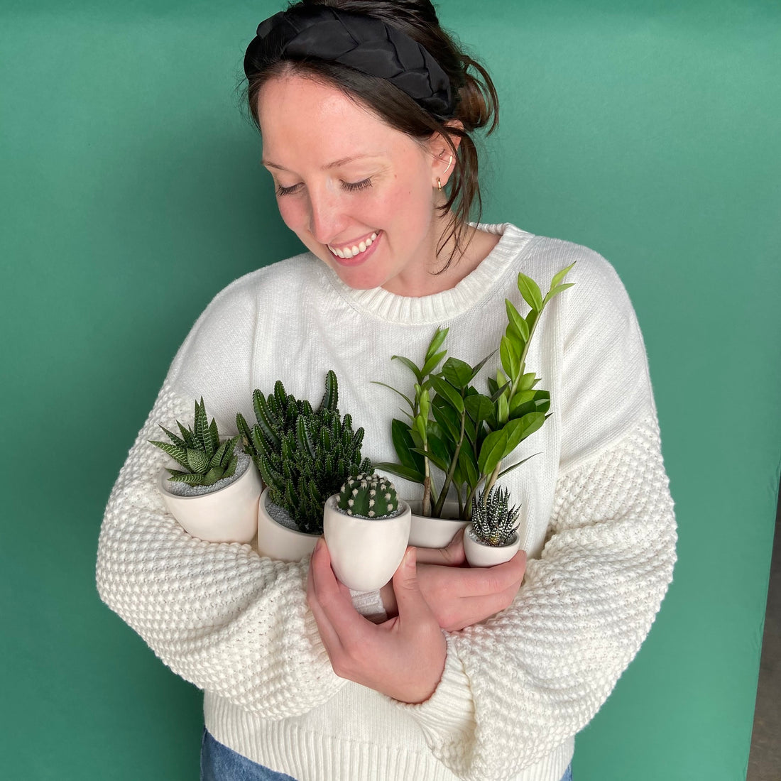 Woman holding seven hardy plants making her happy